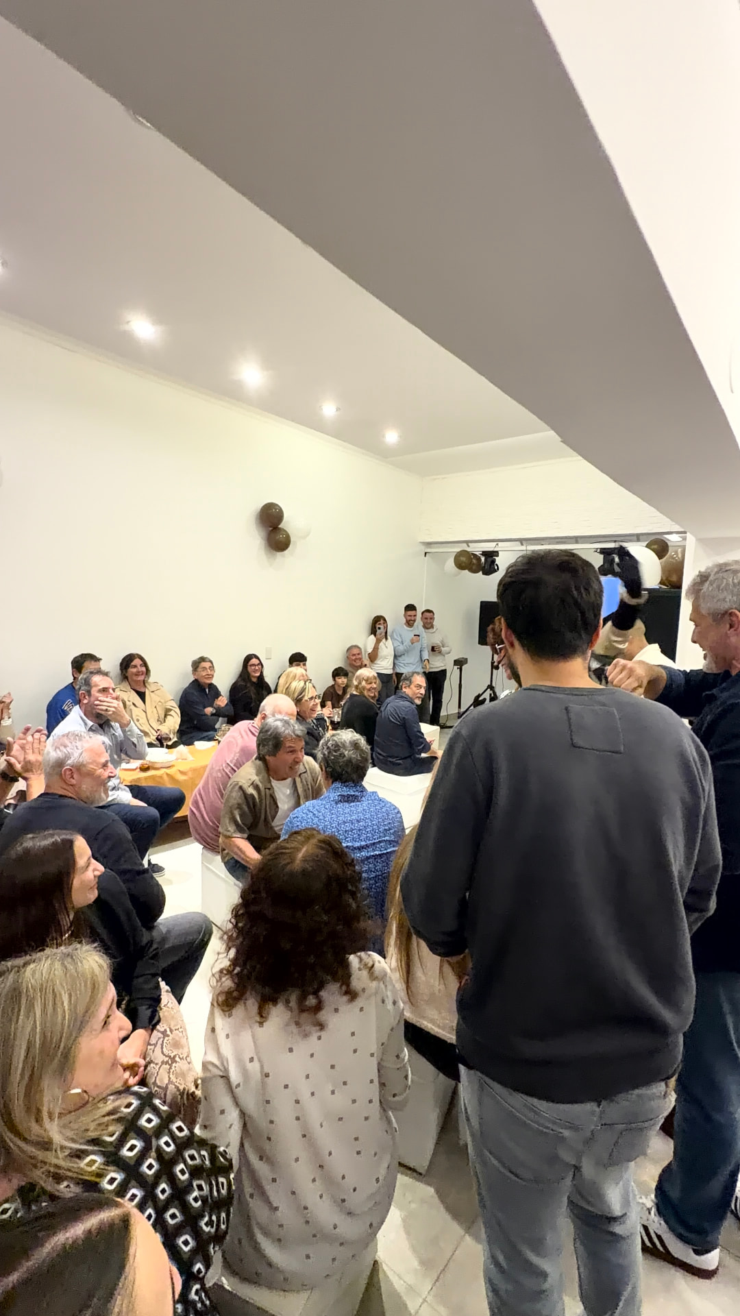 Festejo familiar con invitados sentados y de pie en el salón