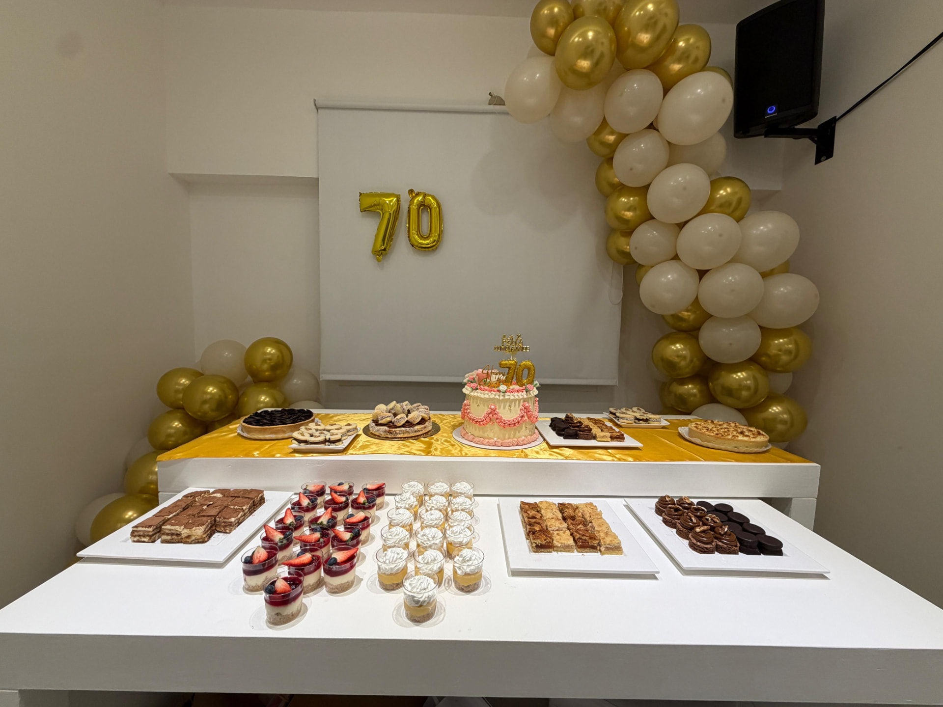 Mesa dulce de cumpleaños de 70 con torta, tiramisú y postres artesanales de Dapont en el salón de Núñez